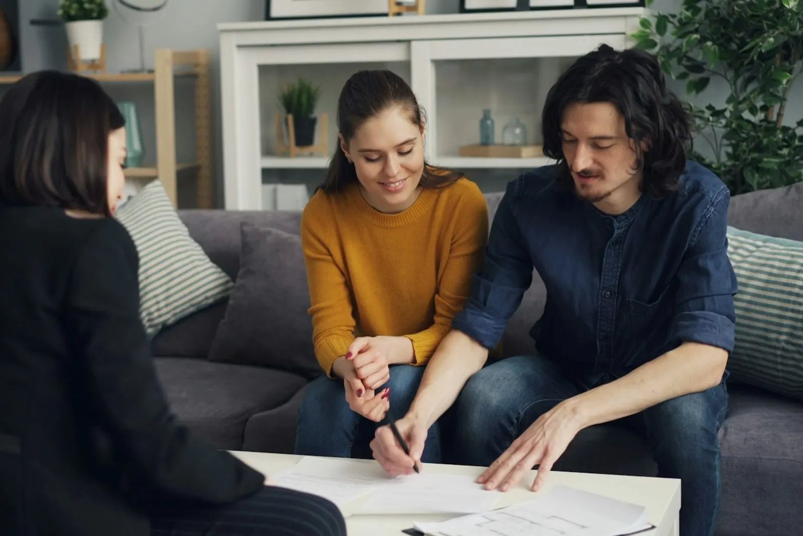Asesora revisando documentos con una pareja